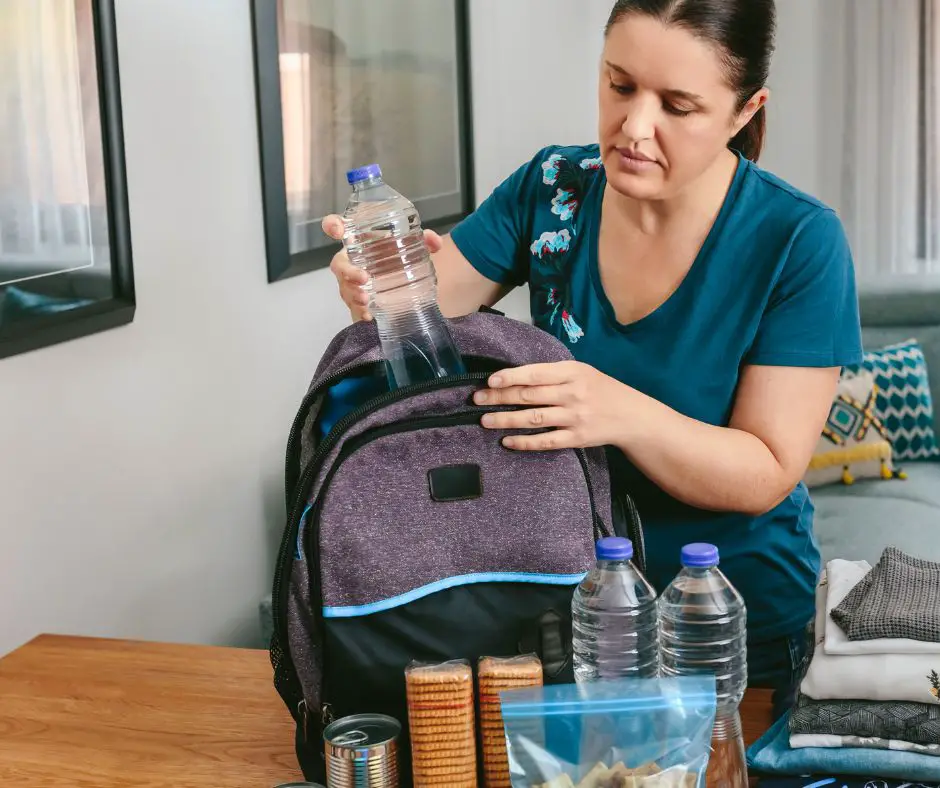 Woman is putting water bottle in the bag