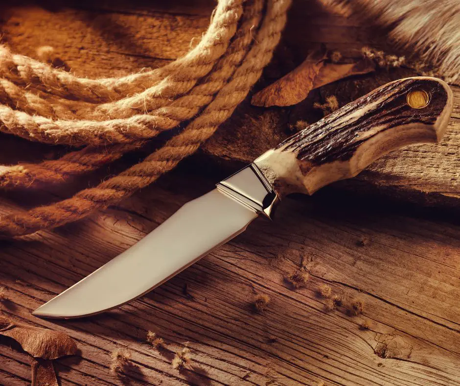 bushcraft knife with wooden handle next to rope